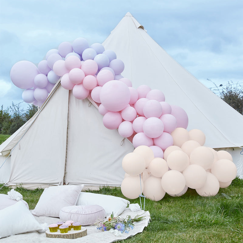tent met roze en paarse ballonnetjes in een boog erop