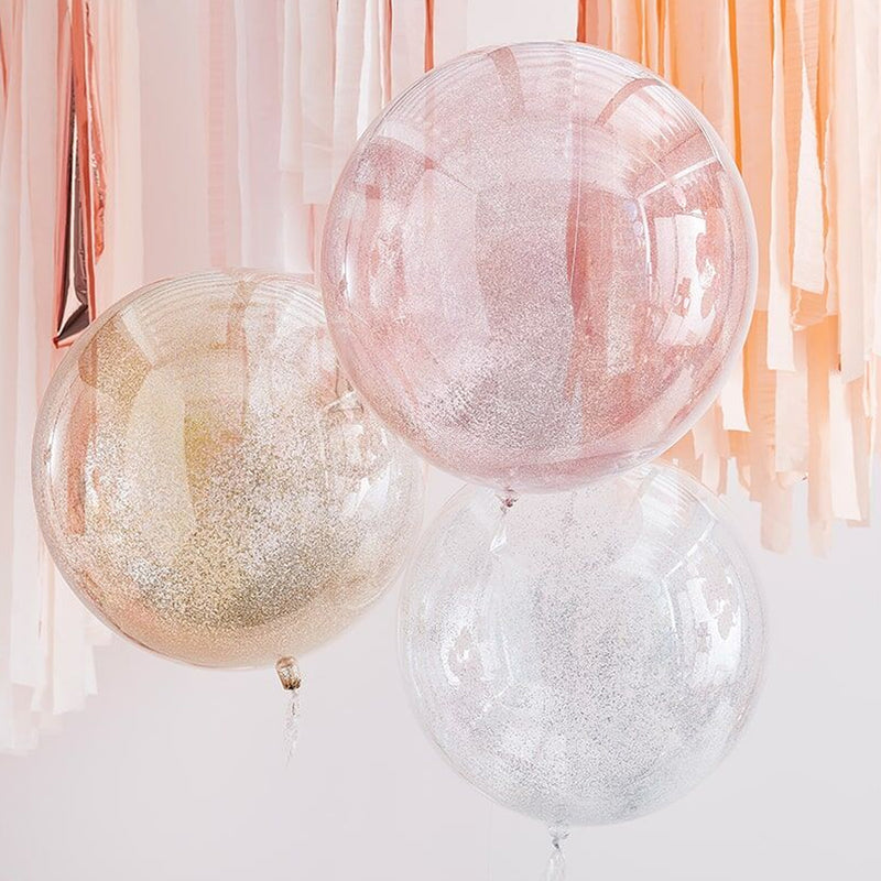 drie grote transparante orbs met glitters erin