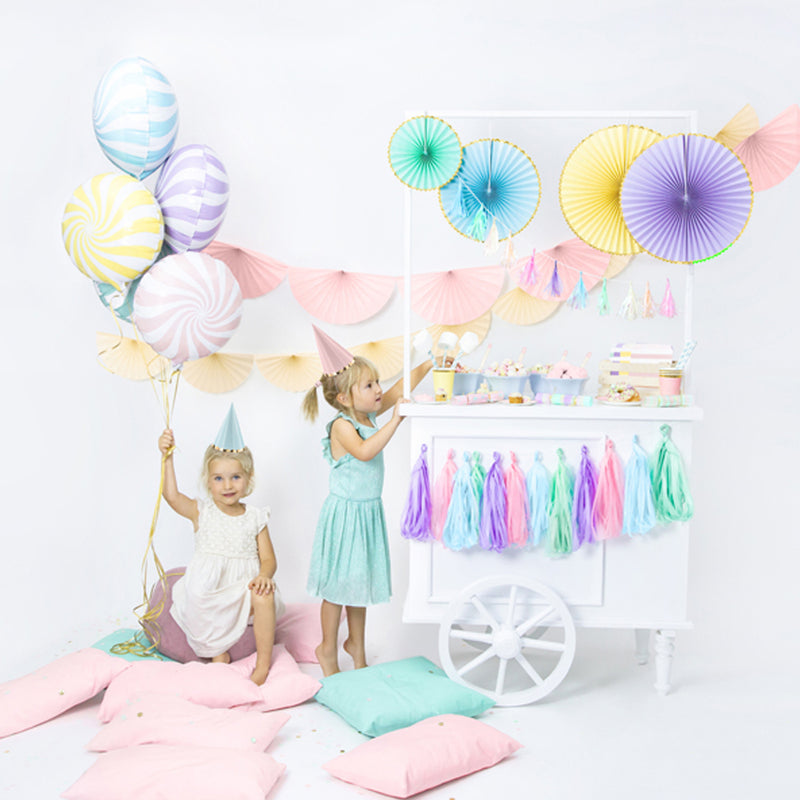 twee kinderen omringd door pastelkleurige feestversiering