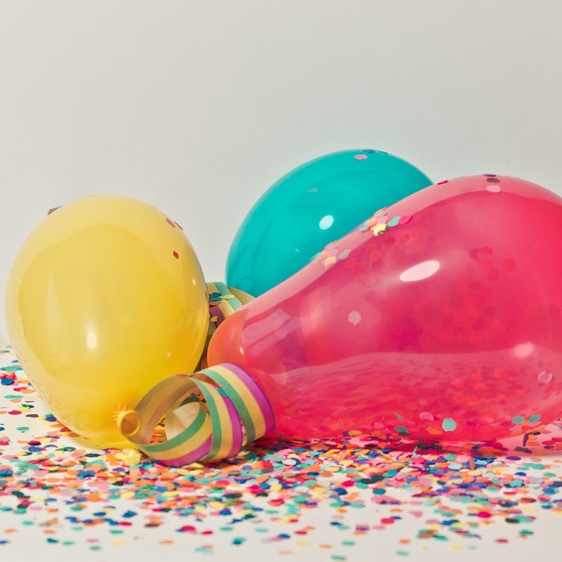 drie ballonnetjes op confetti