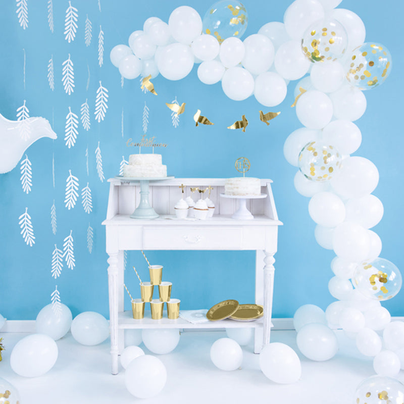 kamer met blauwe muur en witte feestversieringen met witte ballonnen en tafeldecoratie