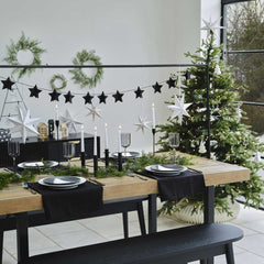 Gedekte tafel met standaard erboven met een sterrenslinger eraan en een kerstboom