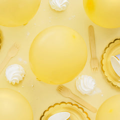 Gele tafel met gele bordjes en balonnen