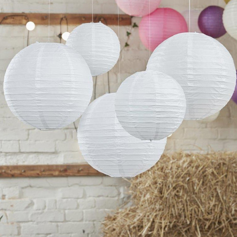 vijf witte lampionnnen in schuur met stro