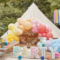 grote tent buiten omringd door kleurrijke feestversiering