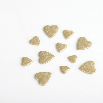 Gouden confetti in de vorm van hartjes gemaakt van was