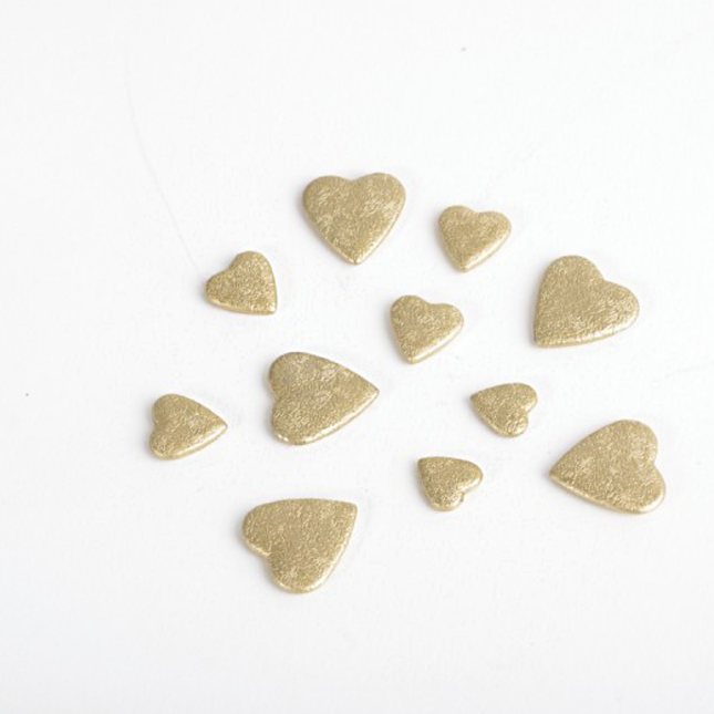 Gouden confetti in de vorm van hartjes gemaakt van was