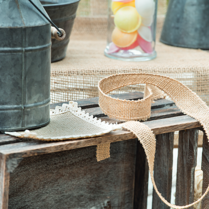 Houten tafel met een ijzeren melkkan, jute servet en jute touw