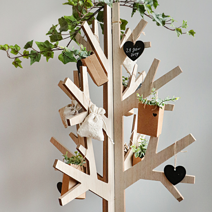 Houten boom versierd met groene bladeren en krijtbord in de vorm van hartjes