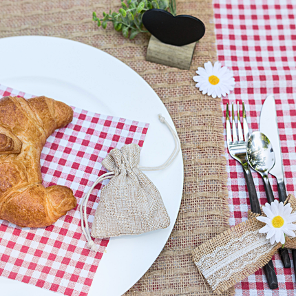 Dinertafel aangekleed met een jute tafelloper en zilveren bestek