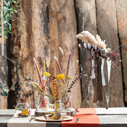 Tafel met rustieke versiering bestaande uit droogbloemen en metalen hangers