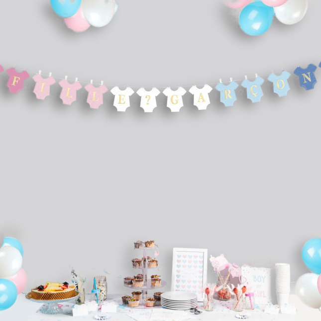 Grijze muur versierd met een slinger met rompers in het blauw, wit en roze