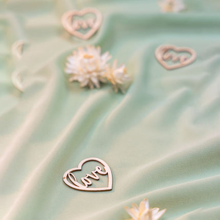 houten hartjes met de tekst love op tafel met saliegroene loper