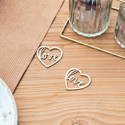 houten hartjes met de tekst love op houten tafel