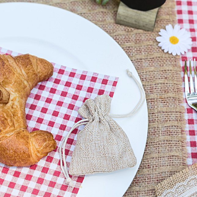 Jute zakje ligt op een wit bord naast een croissant
