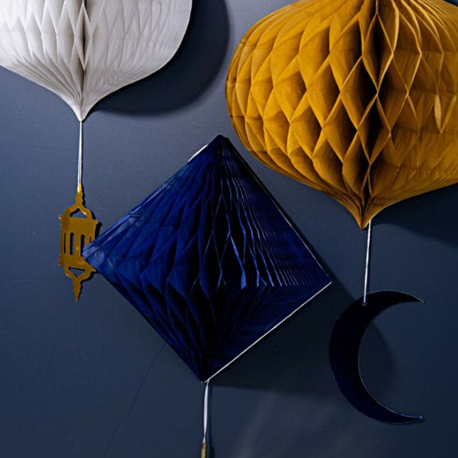 Gouden, witte en donkerblauwe honeycomb plakken aan een blauwe muur