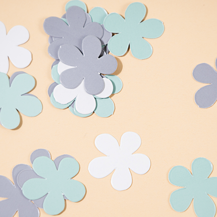 blauwe en witte confetti bloemen liggen op een gele ondergrond