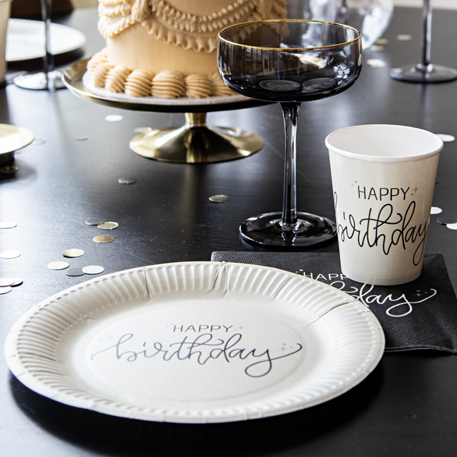 creme bordje met zwarte tekst happy birthday en zwarte tafel versiering