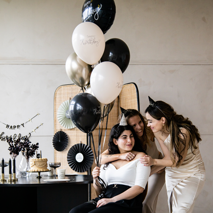 drie vrouwen op een verjaardag met creme en zwarte versiering