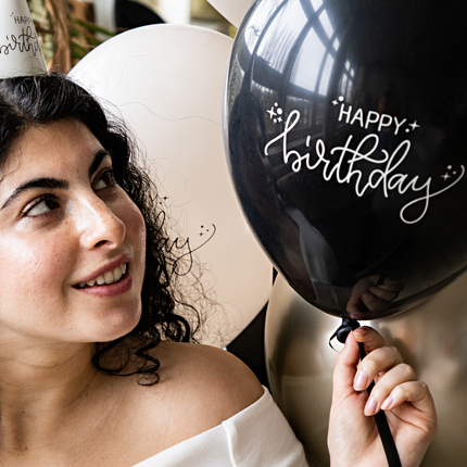 vrouw met een zwarte ballon met de tekst happy birthday