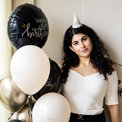 vrouw met zwarte krullen en een tros creme en zwarte ballonnen