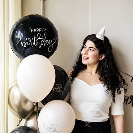 vrouw met zwarte krullen en een tros creme en zwarte ballonnen