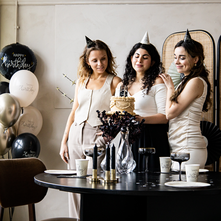 drie vrouwen met zwart en witte feethoedjes op met de tekst happy birthday