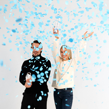 man en vrouw met een confetti kanon met blauwe confetti