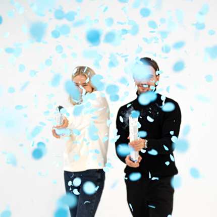 man en vrouw met een confetti kanon met blauwe confetti