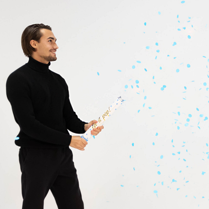 man met confetti kanon met blauwe confetti