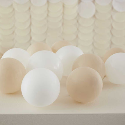 witte en nude kleurige balonnen op de grond