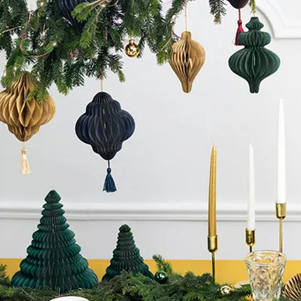Kerstakken met honeycomb hangers in diverse kleuren en vormen met daaronder een tafel met honeycomb kerstboompjes
