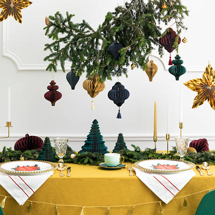 gedekte tafel met kerstgroen en papieren kersthangers