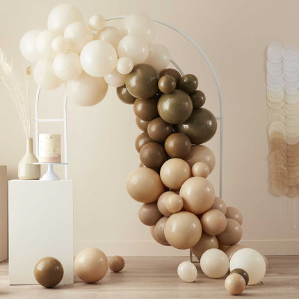Witte metalen boog met daarvoor een boog van bruine witte en taupe kleurige ballonnen