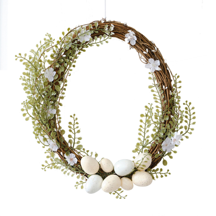 Deurkrans versierd met witte bloemen en paaseieren