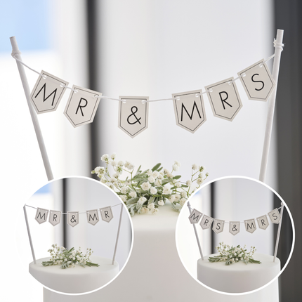 Personaliseerbare taart topper in het wit met zwarte letters zit boven in een taart versierd met witte bloemetjes