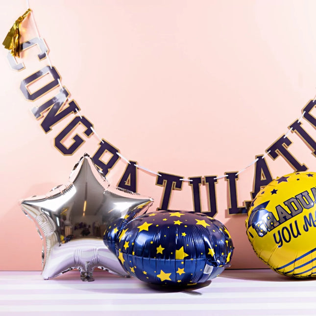 set folieballonnen in het donkerblauw, goud en zilver met sterren en de tekst graduated, you made it!