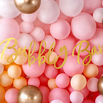 roze ballonnenmuur met gouden details en een gouden slinger the bubbly bar