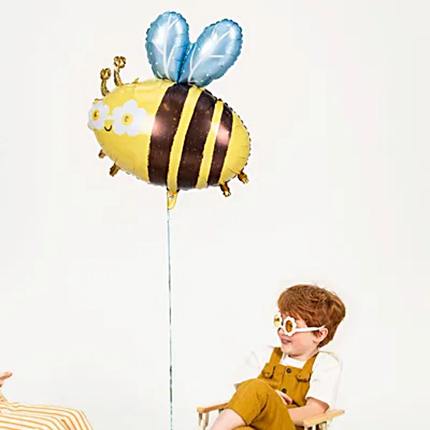 kind wat cooler is dan ik dat ben houd een folieballon vast in de vorm van een hommel