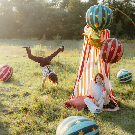 kinderen op circus feestje met blauwe en rode ballonnen met gouden sterren