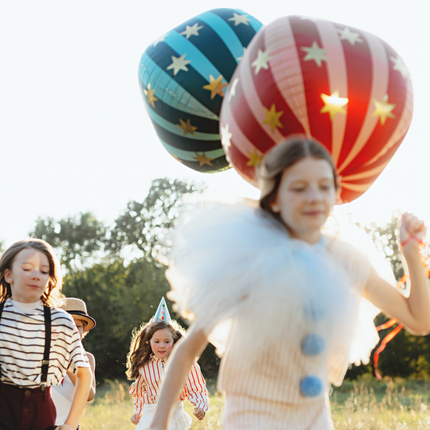 kinderen op circus feestje met blauwe en rode ballonnen met gouden sterren