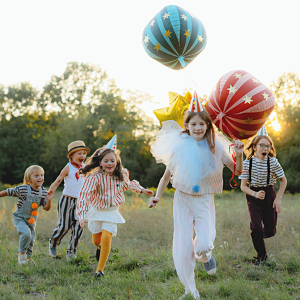kinderen op circus feestje met blauwe en rode ballonnen met gouden sterren
