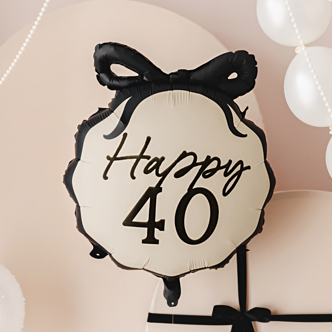 creme ballon met zwarte strik en de zwarte tekst happy 40