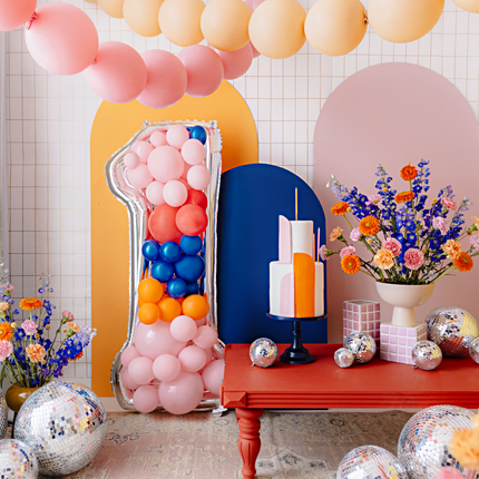 versiering woonkamer met ballonnen slingers en discoballen en een reuze cijfer 1