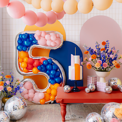 kamer versierd met pastel ballonnen en een reuze cijfer