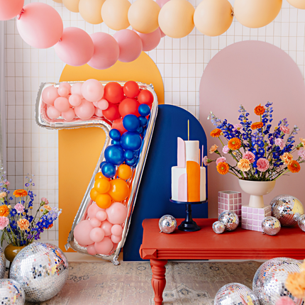kamer versierd met pastel ballonnen en een reuze cijfer