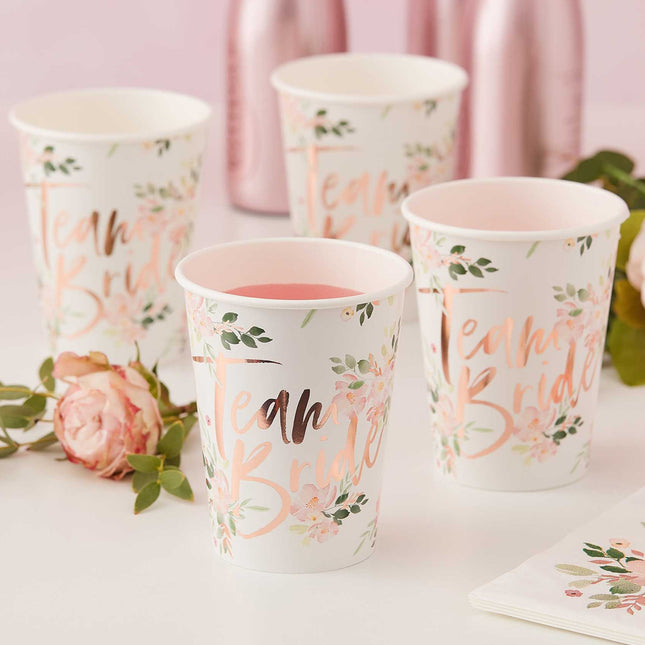 Vier witte bekertjes met bloemenprint en rose gouden tekst met Team bride