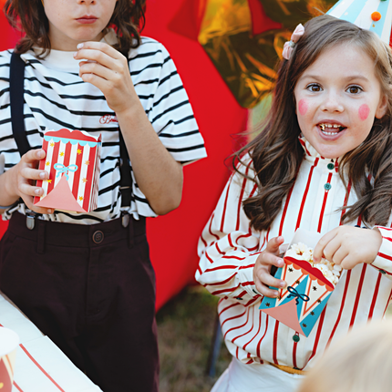 twee kinderen verkeed als clowns hebben circus snackbakjes vast met popcorn
