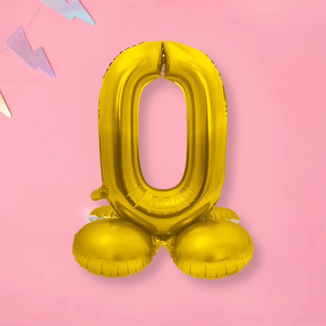 Gouden folieballon op standaard op een roze achtergrond met een vlaggetje met bliksem