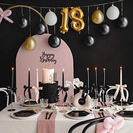 ballonslinger in het zwart en goud met het cijfer 18 hangt boven een oudroze met zwart versierde tafel